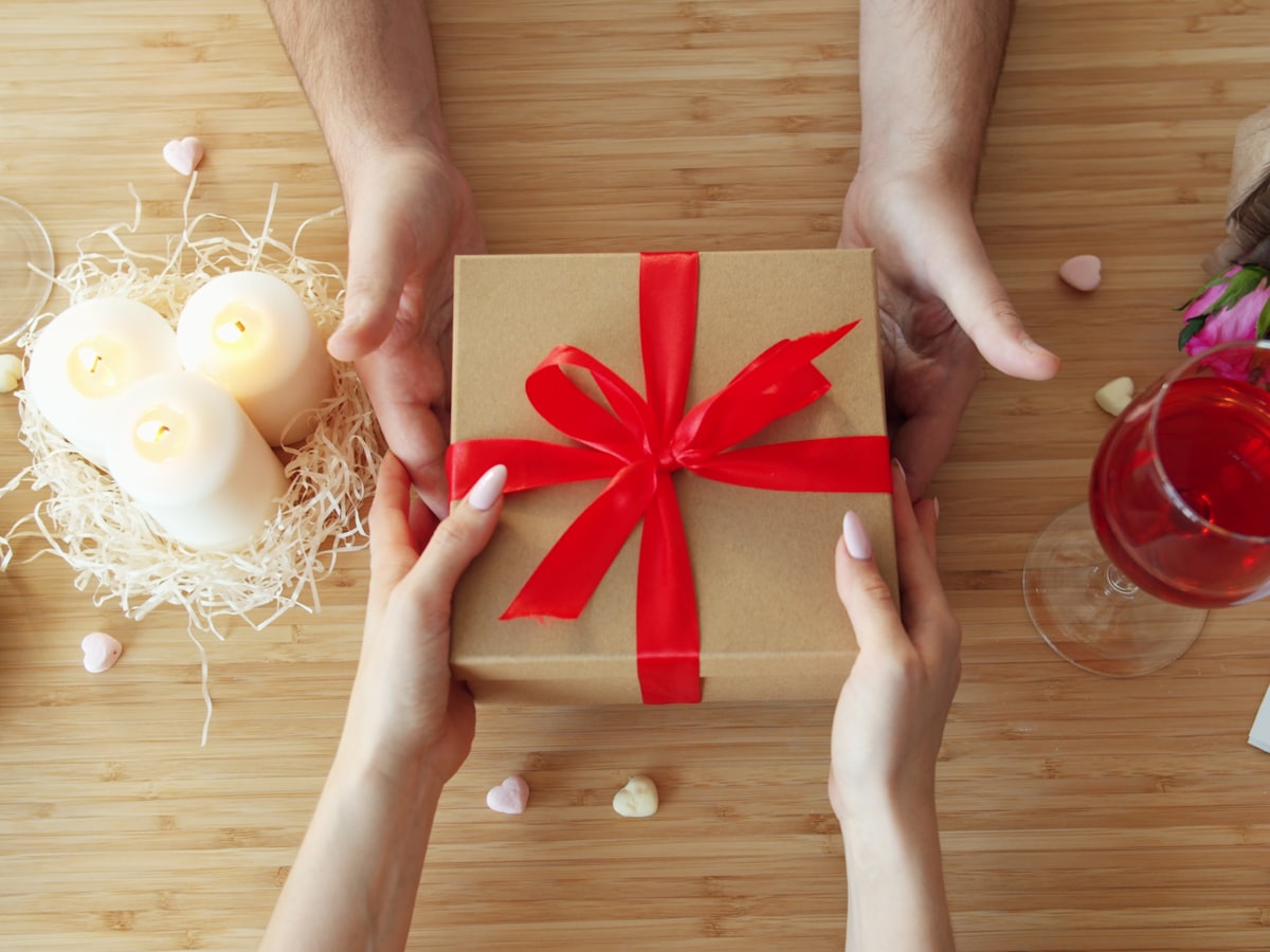 Een cadeau met rood lint wordt overhandigd